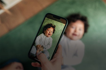 Ao fundo imagem de uma pessoa tirando foto de uma criança