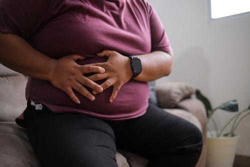 Mulher experimenta desconforto estomacal enquanto relaxa no sofá